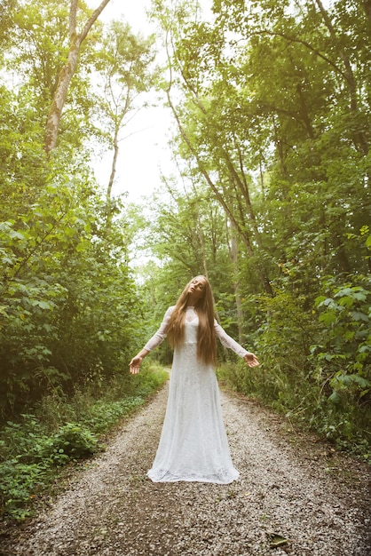 Een vrouw die en zich in het bos bevindt stelt