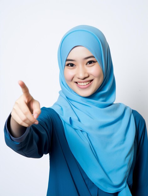 een vrouw die naar links wijst met een blauwe hijab op haar hoofd.