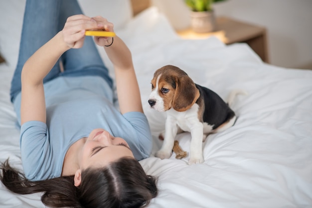 Een vrouw die op bed ligt en selfie maakt