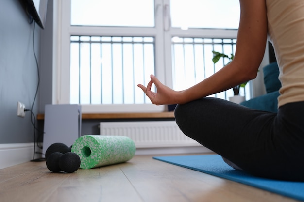 Een vrouw die op de grond zit in een meditatiehouding