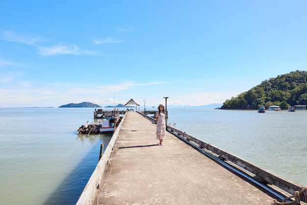 Foto een vrouw die op een cement pier staat langs de zee bij mu ko phetra in thailand