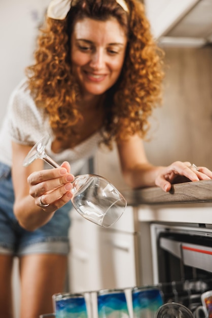 Een vrouw die thuis een afwasmachine gebruikt