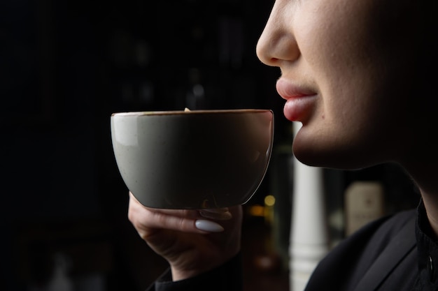 Een vrouw die uit een beker drinkt