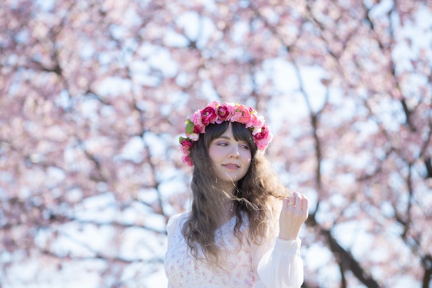 Een vrouw die van kersenbloesems geniet