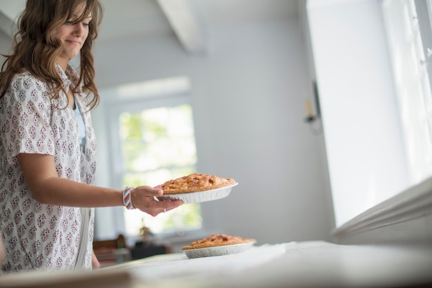 Een vrouw die voedsel naar een tafel draagt en zich klaarmaakt voor een familiemaaltijd