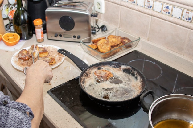 Een vrouw die wentelteefjes maakt in de keuken Een traditie in Spanje om torrijas te eten bij Eastern