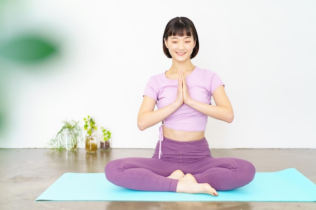 Een vrouw die yoga doet, poseert met haar handpalmen tegen elkaar