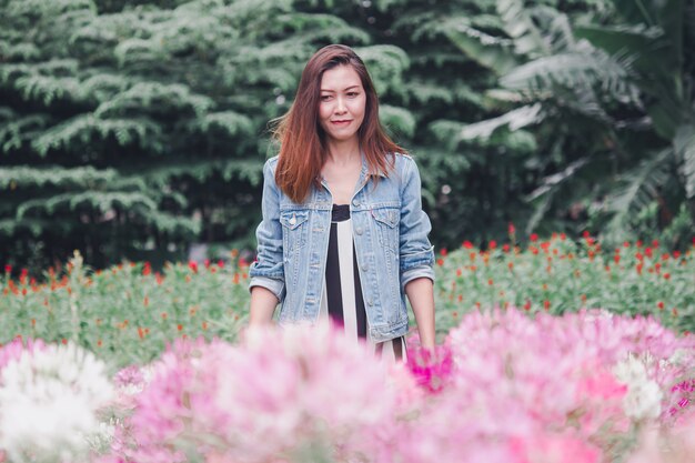 Een vrouw die zich in een roze bloementuin bevindt