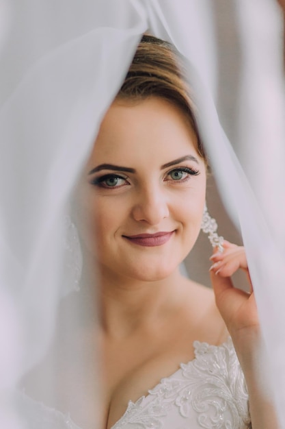 Een vrouw draagt een witte jurk en glimlacht.
