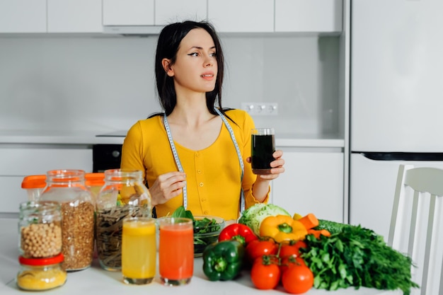 Een vrouw drinkt thuis gezond groen sapGezonde levensstijlVoedingsvoedsel