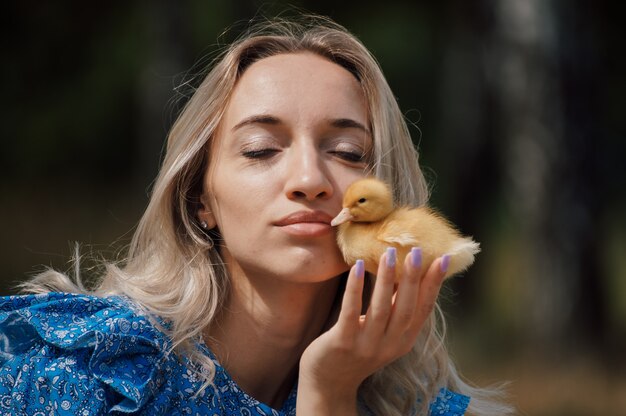 Een vrouw drukt een eend tegen haar gezicht