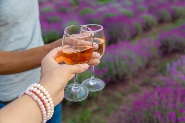 Een vrouw en een man drinken wijn in een lavendelveld Selectieve aandacht