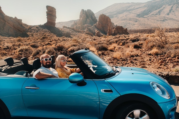 Een vrouw en een man met een bril in een cabriolet op reis naar het eiland Tenerife. De krater van de vulkaan Teide, Canarische Eilanden, Spanje.