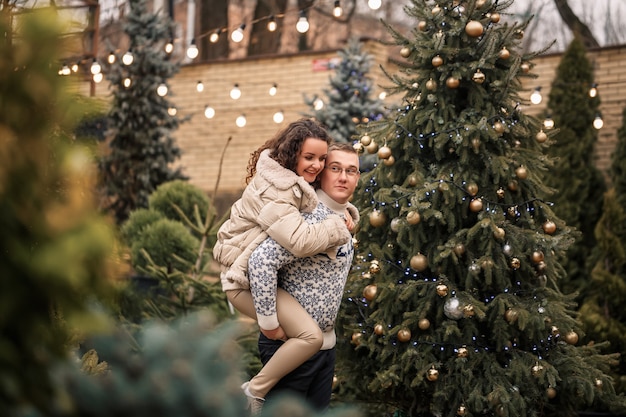 Een vrouw en een man staan bij de kerstboom, ze zijn gelukkig, nieuwjaarsstemming