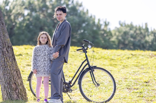 Foto een vrouw en haar dochter staan naast een fiets.