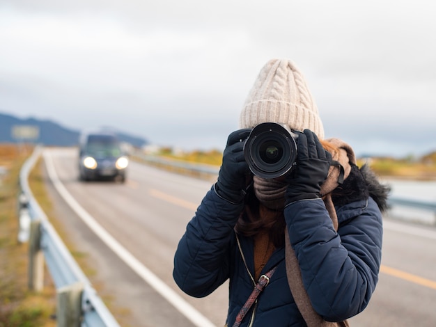 Een vrouw fotografeert prachtige landschappen van Noorwegen