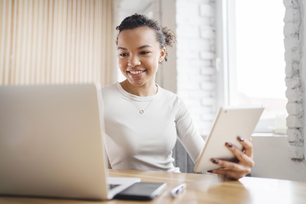 Een vrouw gebruikt een werkplekrapport van een laptopcomputer in het bedrijf en drukt op toetsen die met documenten werken