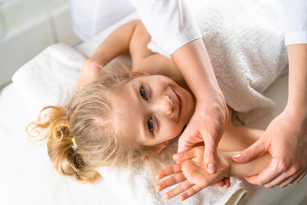 Een vrouw geeft een massage aan een klein meisje kinderen39s massage preventie van scoliose osteopathie