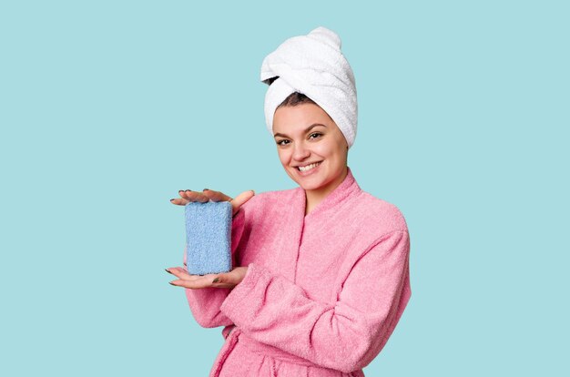 Een vrouw geniet van een moment van ontspanning na het douchen in een zachtroze badjas en een handdoek