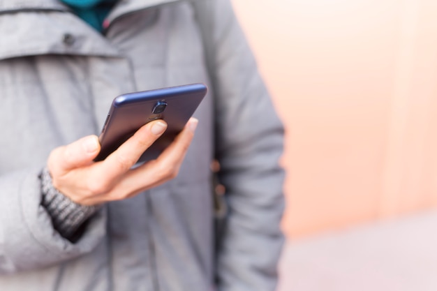 Een vrouw heeft een mobiele telefoon in haar hand.