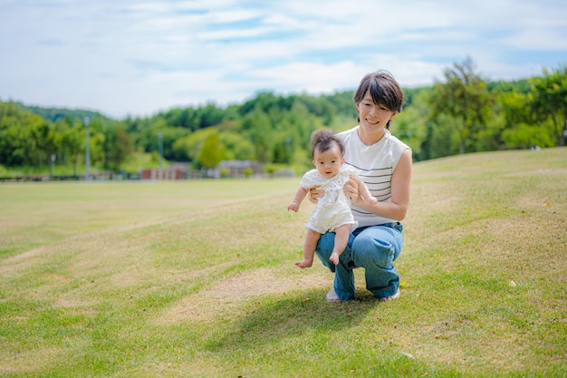 Een vrouw houdt een baby vast in een veld