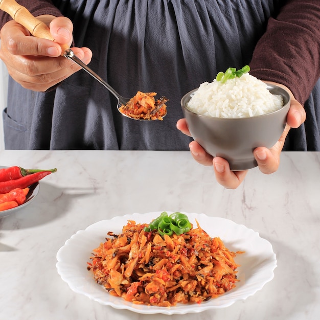 Een vrouw houdt een kom witte rijst met pittige geraspte tonijn vast, Concept Daily Asian (Koreaans Japan Thailand) Menu. Geselecteerde focus