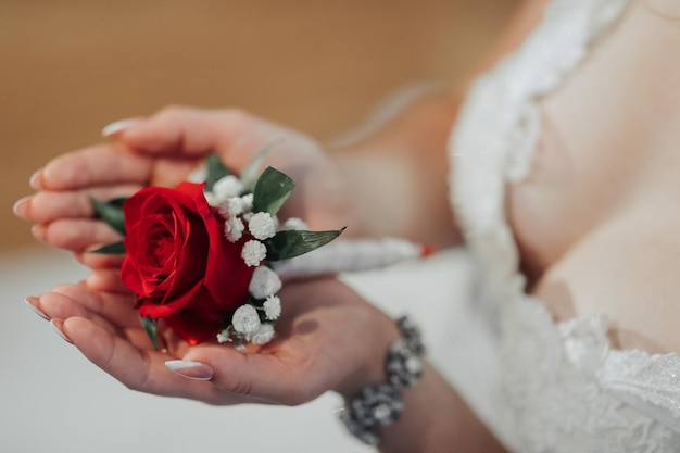 Een vrouw houdt een rode roos in haar hand.