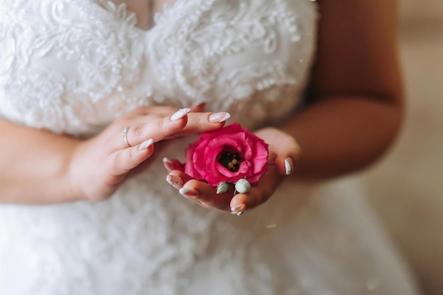 Een vrouw houdt een roze bloem in haar hand.