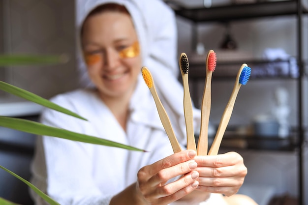 Een vrouw houdt een set bamboe houten tandenborstels Eco-vriendelijk concept van tandheelkundige zorg en tandheelkundige gezondheid