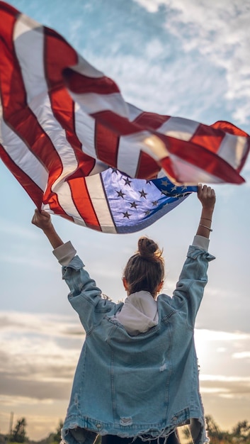 Een vrouw houdt een vlag omhoog met daarop de Verenigde Staten van Amerika