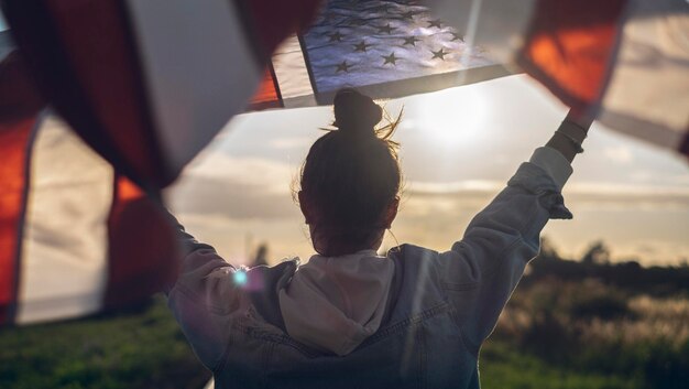 Een vrouw houdt een vlag omhoog met de tekst 'de Amerikaanse vlag' erop