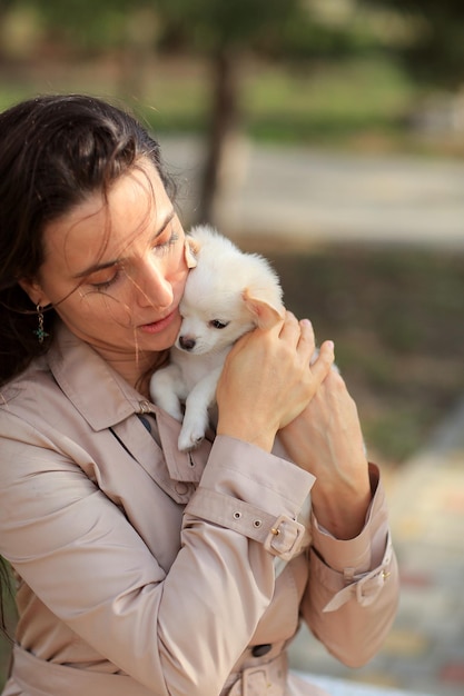 een vrouw houdt een witte puppy vast