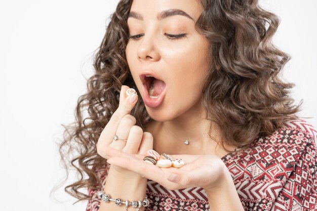 Een vrouw houdt miniatuur donuts in haar handen en laat zien dat ze ze wil opeten