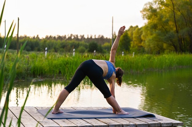 Een vrouw houdt zich bezig met gymnastiek in de natuur. Het concept van sportactiviteit in de natuur.