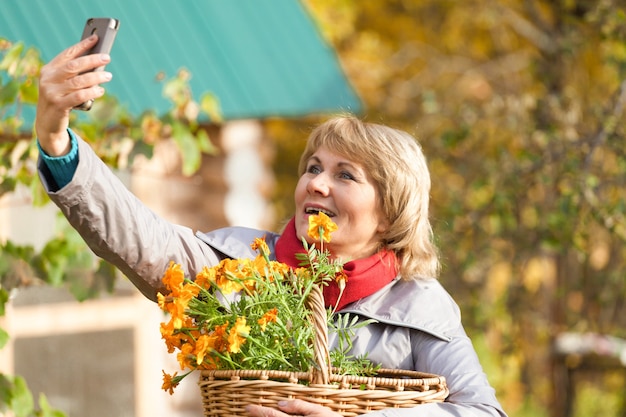 Een vrouw in de herfsttuin oogst en verwijdert afval