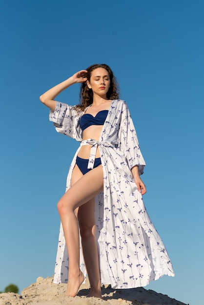 Een vrouw in een blauwe bikini met een blauw-witte kimono