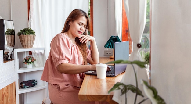 Een vrouw in een cafe met behulp van een laptop jonge blanke vrouw zitten in een coffeeshop druk bezig met laptop