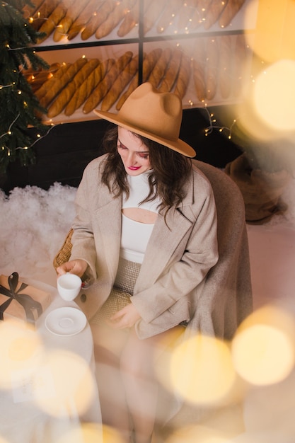 Een vrouw in een coffeeshop drinkt koffie of thee Kerstmis en Nieuwjaar concept
