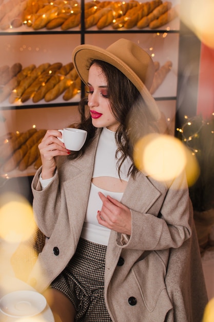 Een vrouw in een coffeeshop drinkt koffie of thee Kerstmis en Nieuwjaar concept