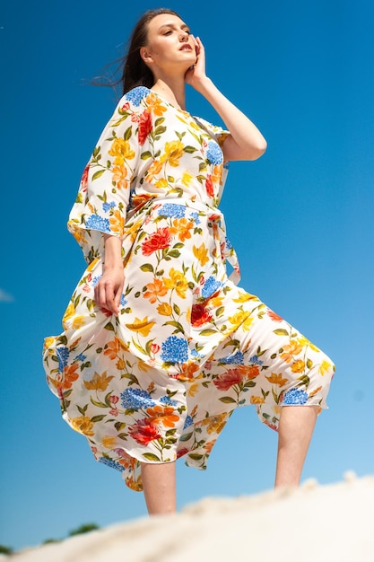 Een vrouw in een gebloemde jurk danst in de zon