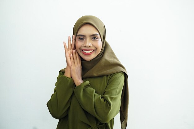 Een vrouw in een groene hijab lacht naar de camera.