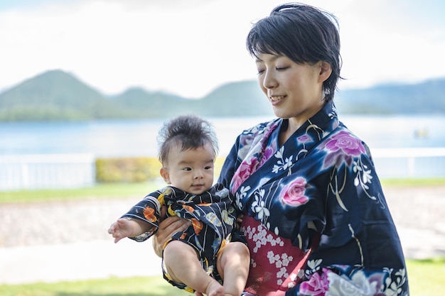 Een vrouw in een kimono houdt een baby vast