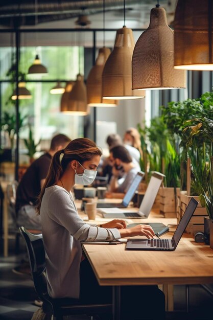 Foto een vrouw in een masker werkt aan een laptop in een kamer met mensen op de achtergrond