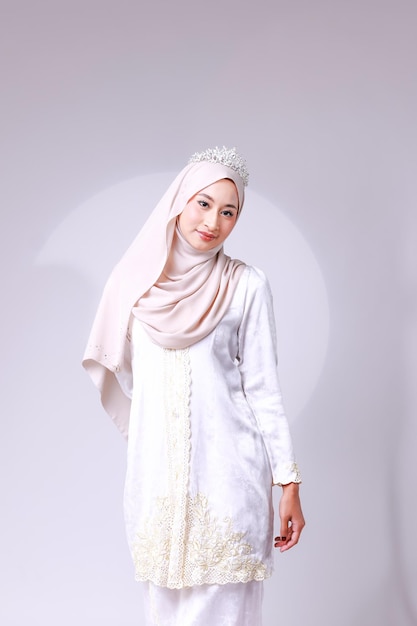 Een vrouw in een witte hijab en een witte jurk
