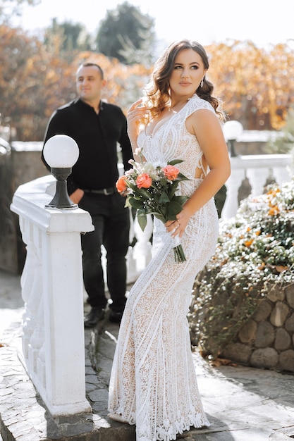 Een vrouw in een witte jurk houdt een boeket bloemen vast.