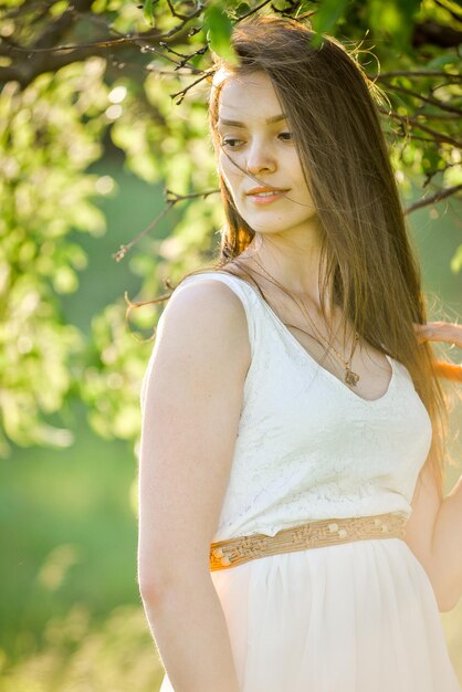 Foto een vrouw in een witte jurk met een gouden gordel