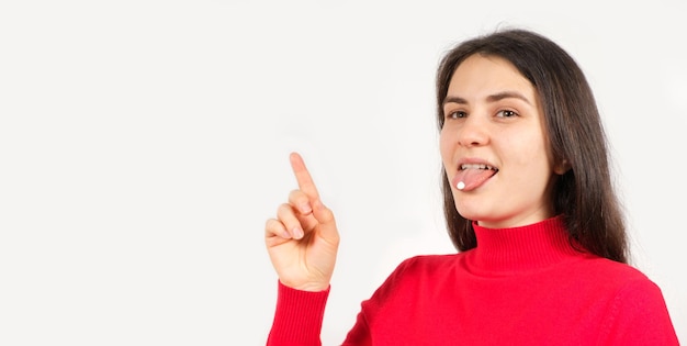 Een vrouw in het rood met pillen op haar tong wijst met haar vinger naar een plek voor tekst