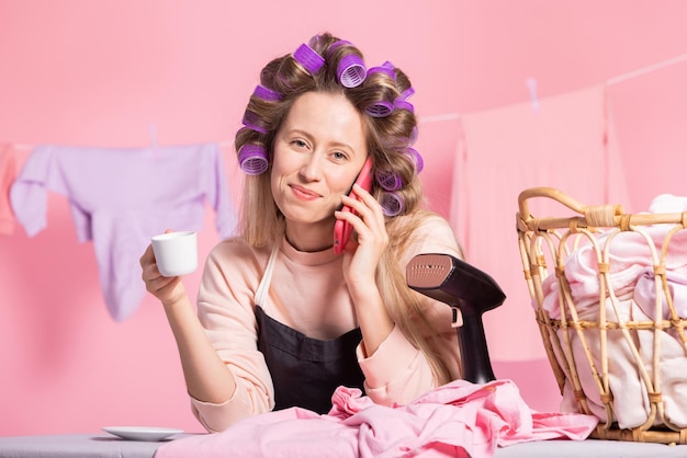 Een vrouw is aan de telefoon met een vriend die roddelt onder het genot van koffie, een pauze van huishoudelijke taken
