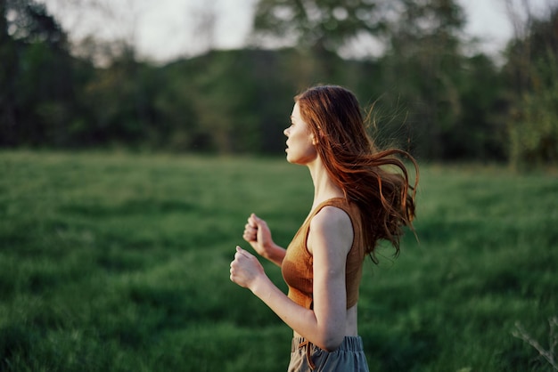 Een vrouw is aan het joggen met een gefocust gezicht, moe na een buitenactiviteit