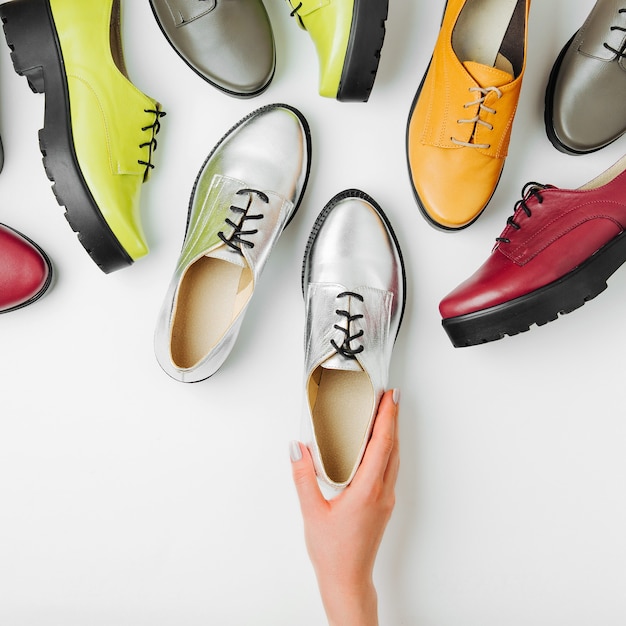 Een vrouw kiest schoenen. Stijlvolle vrouwelijke lente- of herfstschoenen in verschillende kleuren. Schoonheid en mode concept. Platliggend, bovenaanzicht
